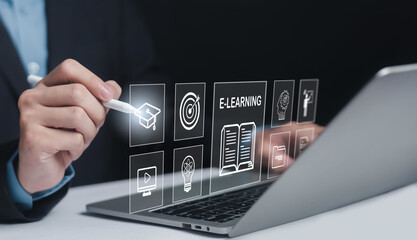 A hand holding a stylus interacts with a digital e-learning interface above a laptop, featuring icons like a graduation cap and a textbook.